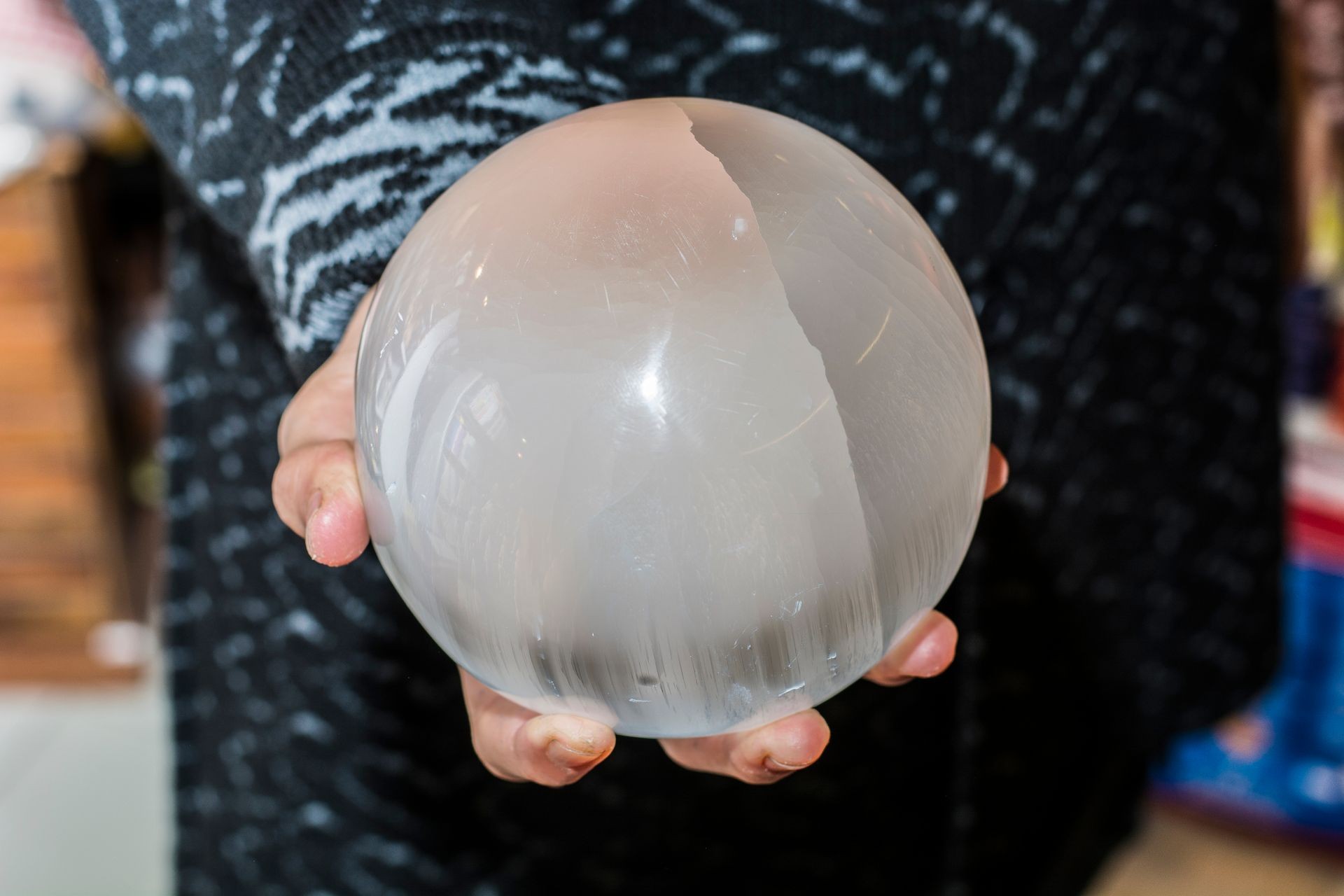 Close up shot of crop female hands holding sphere made of selenite or white quartz. Close up shot of crop female hands holding sphere made of selenite or white quartz.
